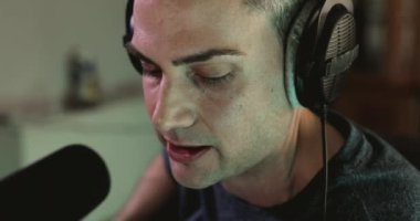 Müzik yapımcısı, bir projenin ses katmanlarını kendi stüdyosundaki kayıt sırasında yerleştirmek için şarkı söylüyor.