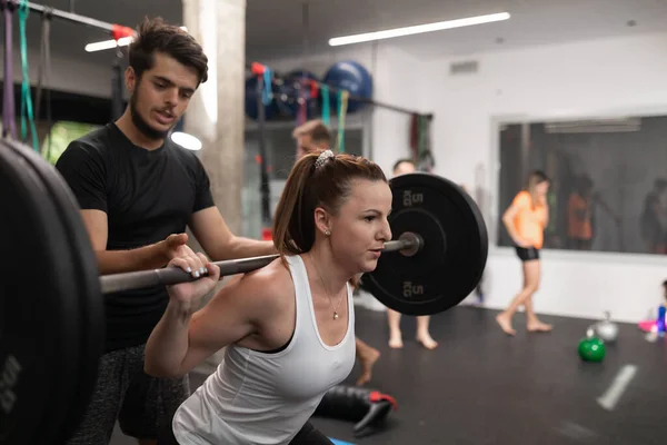 Female Trainee Lifting Weights While Being Guided Her Coach Gym — Foto de Stock
