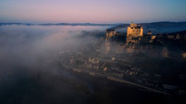aerial view of the castle of Beynac in the fog morning time
