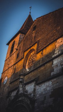 Eski bir katolik kilisesinin alçak açısında, gün batımında, Dordogne 'daki Saint Dominique de Monpazier' de, mavi gökyüzü ile