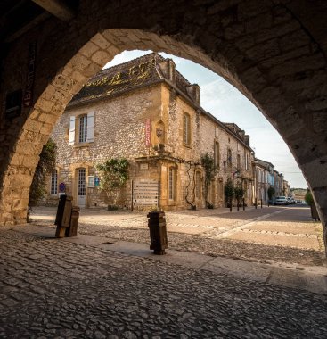 Küçük bir Fransız köyünün kemeri, Fransa 'nın güneyindeki Monpazier' de, Biron kalelerinin yakınında - arka planda belediye binası.