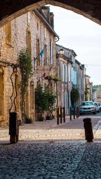 Fransa 'nın güneyinde, Monpazier' deki küçük bir Fransız köyünün kemeriyle orta ölçekli bir çekim. Arka planda, Biron kalelerinin yakınında.