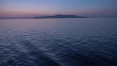 Ship leaving Piraeus port on a Beautiful sunset lights, the Ocean is quiet. Shot onboard a boat