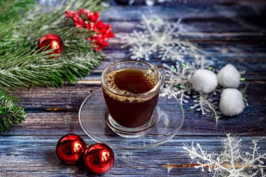 Kahverengi şekerli bir fincan aromatik kahve, Noel süslemeleri, Noel ağacı dalları. Yılbaşı tatili konsepti. Ahşap bir arka planda. Boşluğu kopyala.