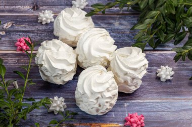 Gül, ortanca ve lale şeklinde hafif bir zemin üzerinde el yapımı marşmelovlar. Yakınlarda çiçekler var. Kadınlar Günü, Sevgililer Günü. Boşluğu kopyala.