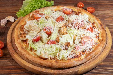 Pastırmalı, peynirli, otlu ve kirazlı pizza. Ahşap zemin üzerinde mozzarella, karides ve ahtapot, midye ve diğer ürünlerle.