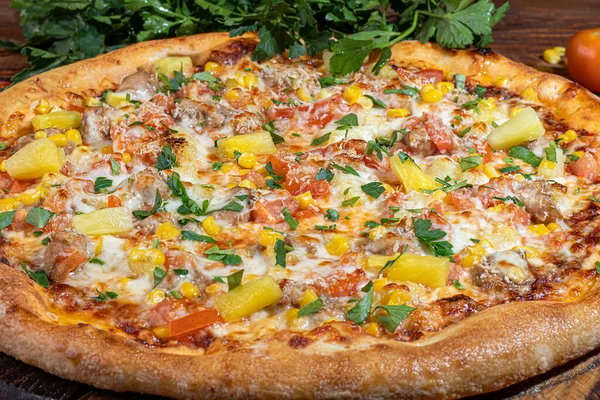 Calzone pizza com bacon e queijo, ervas e tomates cereja. Com mussarela, camarões e polvos, mexilhões e outros produtos sobre fundo de madeira. — Fotografia de Stock