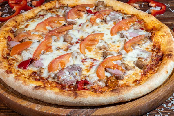 Calzone pizza com bacon e queijo, ervas e tomates cereja. Com mussarela, camarões e polvos, mexilhões e outros produtos sobre fundo de madeira. — Fotografia de Stock