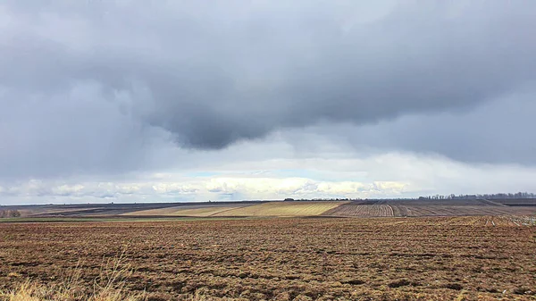 Semeando tempo na Ucrânia durante a guerra. Preparação de campos para semear grãos. Céu azul, terra arada. terror. — Fotografia de Stock