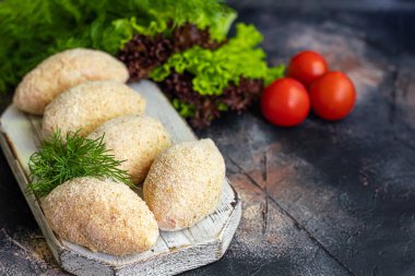 Ekmekli peynir ya da tereyağlı yarı pişmiş pirzola. Fast food hazırlığı. Karanlık bir arka planda. Boşluğu kopyala.