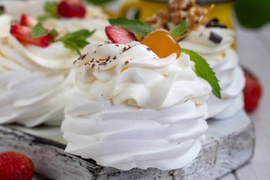 Krem şantili ve taze çilekli Pavlova kremalı kekler, nane yaprağı. Seçici odaklanma. Boşluğu kopyala.
