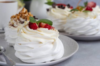Krem şantili ve taze çilekli Pavlova kremalı kekler, nane yaprağı. Seçici odaklanma. Boşluğu kopyala.