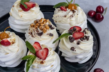 Krem şantili ve taze çilekli Pavlova kremalı kekler, nane yaprağı. Seçici odaklanma. Boşluğu kopyala.