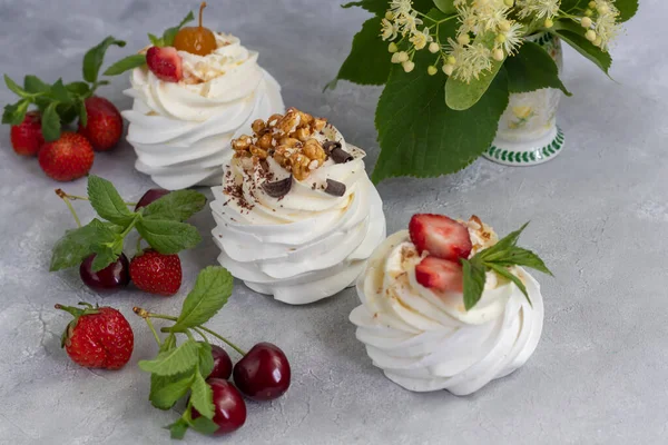 Pavlova meringue cakes with whipped cream and fresh strawberries, mint leaves. Selective focus. copy space.