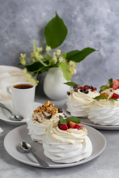 Pavlova meringue cakes with whipped cream and fresh strawberries, mint leaves. Selective focus. copy space.