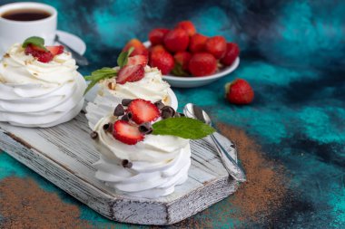 Krem şantili ve taze çilekli Pavlova kremalı kekler, nane yaprağı. Seçici odaklanma. Boşluğu kopyala.