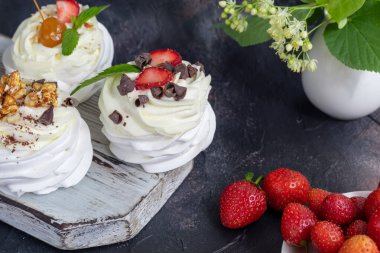 Krem şantili ve taze çilekli Pavlova kremalı kekler, nane yaprağı. Seçici odaklanma. Boşluğu kopyala.