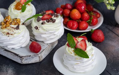 Krem şantili ve taze çilekli Pavlova kremalı kekler, nane yaprağı. Seçici odaklanma. Boşluğu kopyala.