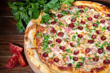 Pizza with bacon and cheese, herbs and cherry tomatoes. With mozzarella, shrimp and octopus, mussels and other products on a wooden background. fast food