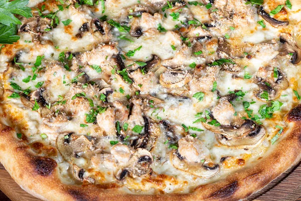 Pizza with bacon and cheese, herbs and cherry tomatoes. With mozzarella, shrimp and octopus, mussels and other products on a wooden background. fast food