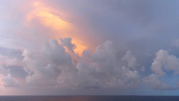 Caribbean clouds painted gold at sunset
