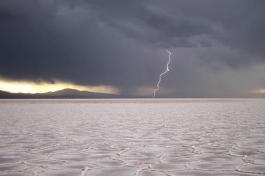 Gün batımında tuzlu ve düz çölde fırtına