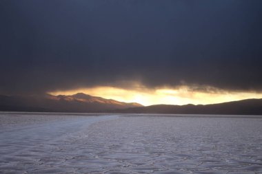 Gün batımında tuzlu ve düz çölde fırtına