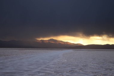 Gün batımında tuzlu ve düz çölde fırtına