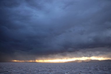 Gün batımında tuzlu ve düz çölde fırtına