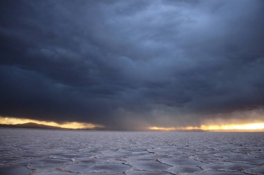 Gün batımında tuzlu ve düz çölde fırtına