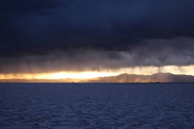 Gün batımında tuzlu ve düz çölde fırtına