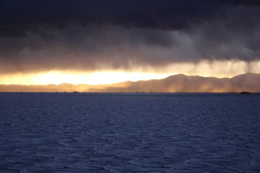 Gün batımında tuzlu ve düz çölde fırtına
