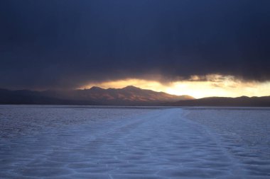 Gün batımında tuzlu ve düz çölde fırtına