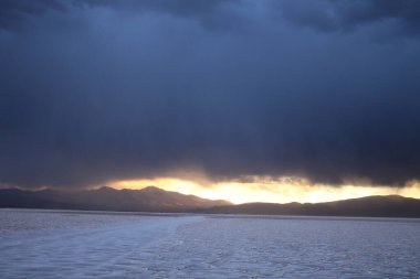 Gün batımında tuzlu ve düz çölde fırtına