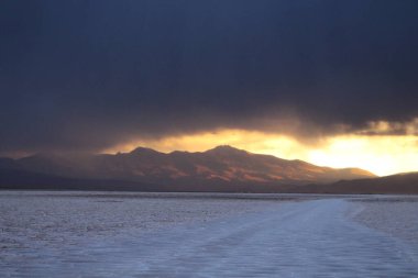 Gün batımında tuzlu ve düz çölde fırtına
