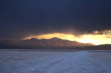 Gün batımında tuzlu ve düz çölde fırtına