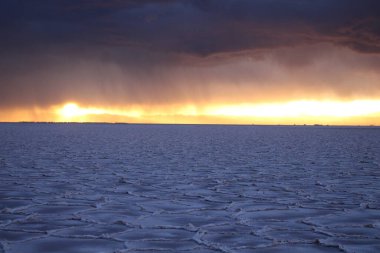 Gün batımında tuzlu ve düz çölde fırtına