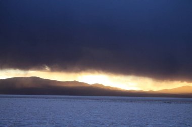 Gün batımında tuzlu ve düz çölde fırtına