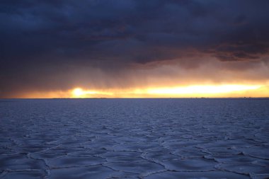 Gün batımında tuzlu ve düz çölde fırtına