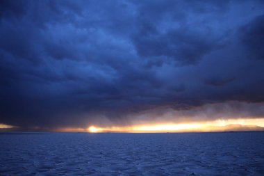 Gün batımında tuzlu ve düz çölde fırtına