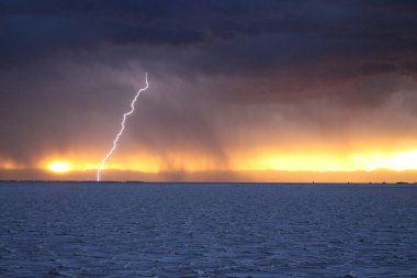 Gün batımında tuzlu ve düz çölde fırtına