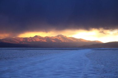 Gün batımında tuzlu ve düz çölde fırtına