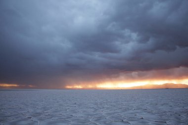Gün batımında tuzlu ve düz çölde fırtına