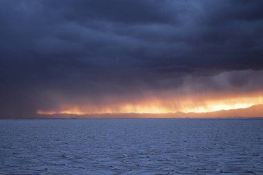Gün batımında tuzlu ve düz çölde fırtına