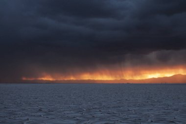 Gün batımında tuzlu ve düz çölde fırtına