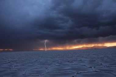 Gün batımında tuzlu ve düz çölde fırtına