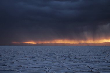 Gün batımında tuzlu ve düz çölde fırtına