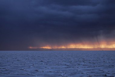 Gün batımında tuzlu ve düz çölde fırtına