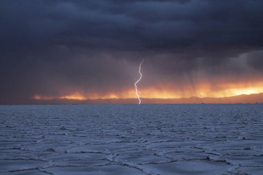 Gün batımında tuzlu ve düz çölde fırtına