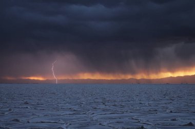 Gün batımında tuzlu ve düz çölde fırtına